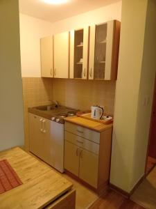 eine Küche mit weißen Schränken und einem Waschbecken in der Unterkunft Divčilend-Mesko vajat in Divčibare