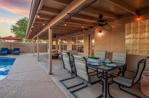 a patio with a table and chairs next to a pool at Luxe Phoenix Getaway (heated pool, mountain view) in Phoenix