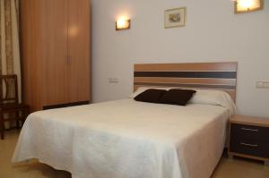 a bedroom with a large white bed with two pillows on it at Pension Canadiense in Barcelona