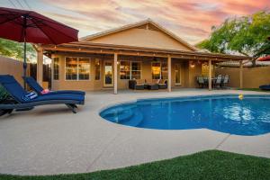 uma piscina com duas cadeiras e um guarda-sol em Luxe Phoenix Getaway (heated pool, mountain view) em Phoenix