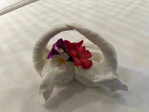 a towel with flowers in it on a bed at The Five Senses Boutique Hotel in Siem Reap