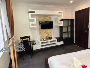a bedroom with a bed and a tv on a wall at The Five Senses Boutique Hotel in Siem Reap