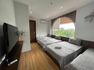 a living room with three beds and a large window at Ninh Binh Truong Nhan homestay in Ninh Binh
