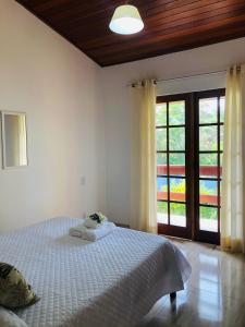 een slaapkamer met een wit bed met bloemen erop bij Casa Ramildes Paraty flat 5 in Paraty