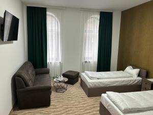 una habitación de hotel con 2 camas y una silla en Weißes Haus, en Plauen