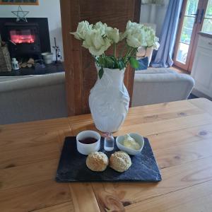 un vase avec un bouquet de fleurs et de beignets sur une table dans l'établissement The Dovecote, à Launceston