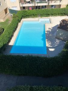 a large blue swimming pool in a yard at Studio dans résidence avec piscine in Montpellier