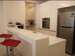 a kitchen with a white counter and a refrigerator at jazz suite 2 bedroom sea view apartment in Tanjung Bungah