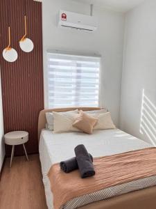 ein Schlafzimmer mit einem Bett mit zwei Kissen darauf in der Unterkunft Seindah Seribong Homestay KB in Kota Bharu