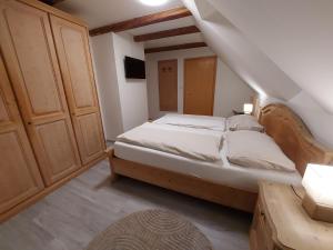 - une chambre avec un lit et une tête de lit en bois dans l'établissement Wollsdorferhof, à Sankt Ruprecht an der Raab
