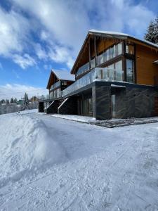 dom w śniegu z kupą śniegu w obiekcie SevenHills chalet w mieście Jabłonica