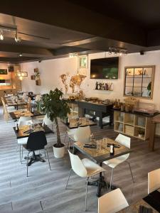 a restaurant with tables and chairs in a room at Standing Hotel Suites by Actisource in Roissy-en-France