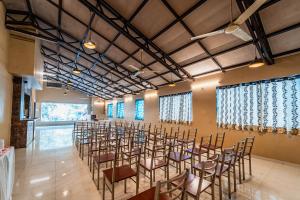 a room with rows of chairs in a room with windows at Treebo Trend Bright Plaza in Mahabaleshwar