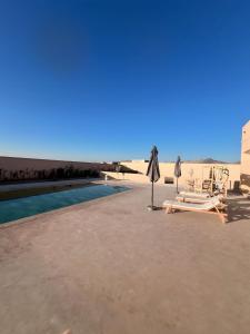 a resort with a pool and chairs and an umbrella at Marrakech Luxury Villa 