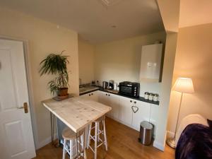 uma pequena cozinha com mesa e bancada em Cosy stable conversion between Sheffield & Leeds em Pontefract