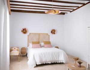Un dormitorio con una cama con sábanas blancas y almohadas rosas. en El Bálsamo - Hotel Rural 5 Estrellas, en Belmonte 236 fotos más