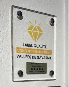 a sign on a wall with a yellow diamond at Gîte Pyrénées Riders in Salles