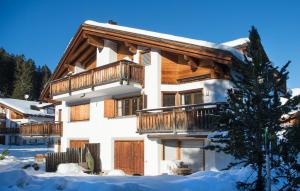 a large house with a balcony in the snow at Holiday flat for 6 people Sot Valos Lenzerheide centre in Lenzerheide
