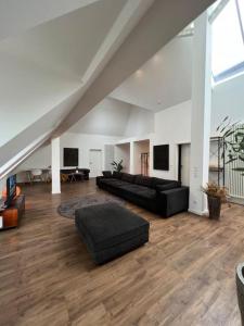 un grand salon avec un mobilier noir et un grenier dans l'établissement Urban Charm Design Loft, à Coblence