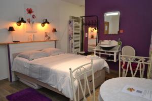 1 dormitorio con cama, espejo y lavamanos en la maison des coquelicots, en Saint-Genès-de-Fronsac