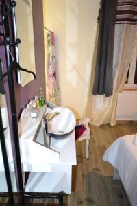 Baño blanco con lavabo y espejo en la maison des coquelicots, en Saint-Genès-de-Fronsac
