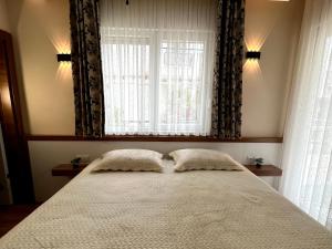 a bed with two pillows in front of a window at Ada APART&HOTEL in Antalya