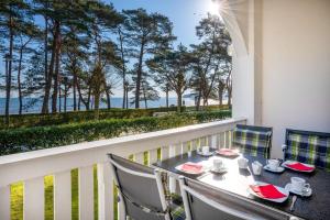 a table and chairs on a balcony with a view of the ocean at Villa-Strandidyll-Binz-Typ-3-Apartment-4 in Binz