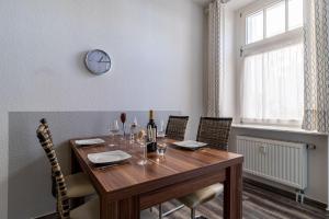 a dining room table with chairs and a clock on the wall at Villa-Strandidyll-Binz-Typ-3-Apartment-4 in Binz