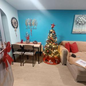 a living room with a christmas tree and a couch at Guesthouse Aggelos Porto Germeno in Porto Germeno