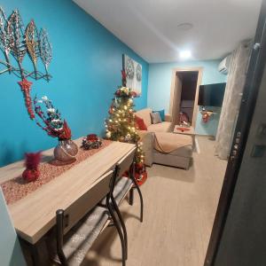 a living room with a christmas tree and a couch at Guesthouse Aggelos Porto Germeno in Porto Germeno