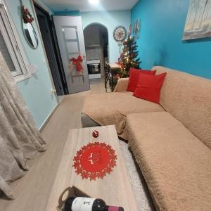 a living room with a couch and a christmas tree at Guesthouse Aggelos Porto Germeno in Aigosthena