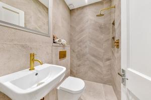 a bathroom with a sink and a toilet and a shower at The Knightsbridge Deluxe Apart in London