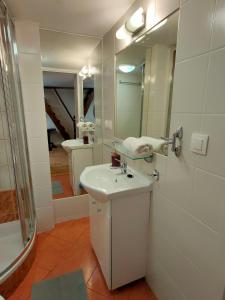 a white bathroom with a sink and a mirror at Krakow Old Town Apartment in Krakow