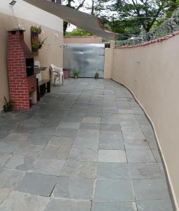 un patio con suelo de piedra y pared en Espaço Mar Doce Lar - Praia Indaiá e Riviera, en Bertioga