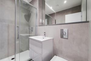 a bathroom with a toilet and a shower and a sink at Kensington Studios in London