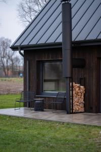 ein Gebäude mit einer Terrasse mit einem Stapel Feuerholz in der Unterkunft Daczowisko in Gruczno