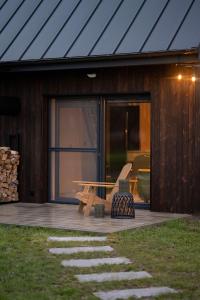 a wooden cabin with a bench and a patio at Daczowisko in Gruczno