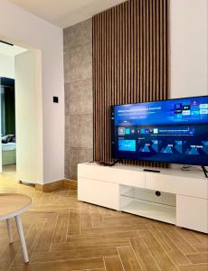 a living room with a large television on a white cabinet at Apartament Ula in Nysa