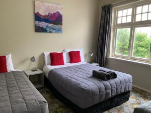 una camera da letto con un grande letto con cuscini rossi di Thomas's Catlins Lodge and Camp Ground a Owaka