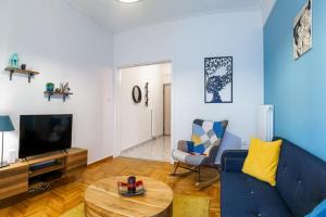 a living room with a blue couch and a table at 4 Family and Friends - Acropolis view in Athens