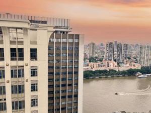 ein hohes Gebäude neben einem Gewässer in der Unterkunft 广州沃家国际公寓 in Guangzhou
