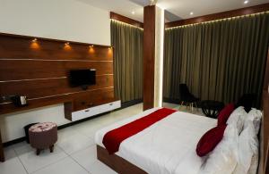 a hotel room with a bed and a television at hotel 24inn residency in Pathanāmthitta
