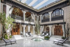 un cortile interno con piscina e sedie di La Sultana Marrakech a Marrakech