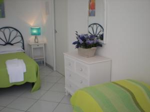ein Schlafzimmer mit einem Bett und eine Kommode mit einer Pflanze darauf in der Unterkunft Residenze Azzurra in Ponza
