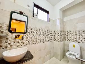 ein Bad mit einem Waschbecken und einem Spiegel in der Unterkunft Hotel SHIVAM ! Varanasi Forɘigner's-Choice ! fully-Air-Conditioned-hotel, lift-and-Parking-availability near-Kashi-Vishwanath-Temple and-Ganga-ghat in Varanasi