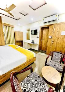 une chambre d'hôtel avec un lit, une table et des chaises dans l'établissement Hotel Skylight Silverkey by Madhav, à Mathura