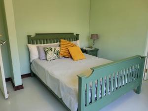 a green bed with pillows on it in a bedroom at Arum Lily Guest Rooms in Pretoria +13 photos
