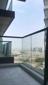 desde un balcón de cristal con vistas a un edificio en Cosy studio in a new building -Brand New nice view, en Dubái