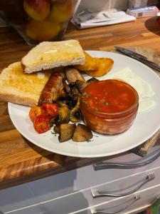a plate of food with sausage mushrooms and bread at South Lodge House in Dormans Land