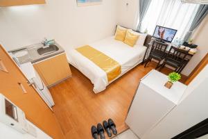 um pequeno quarto com uma cama e uma pequena cozinha em KYARA HOTEL 亀戸b em Tóquio